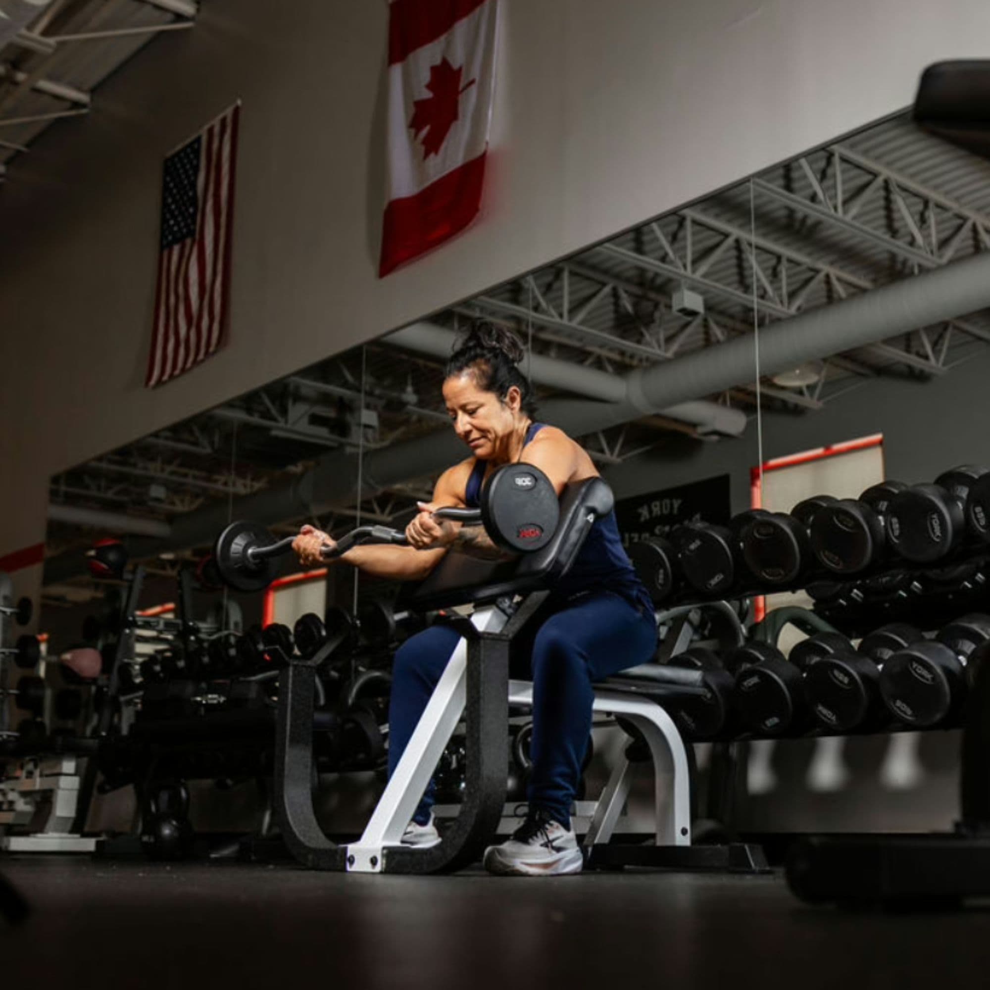 York FTS Preacher Curl Bench With A Woman Performing An Exercise On Gym Settings