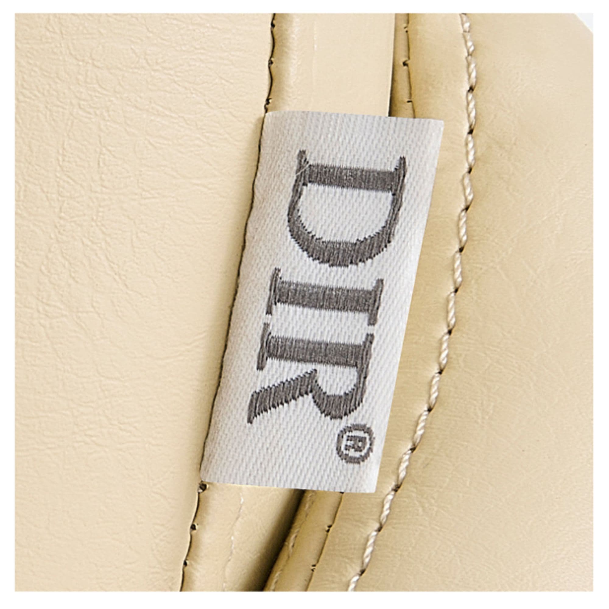Yume Dreaming Electric Shampoo Station Close-Up View Of Vertical Stitched Beige Upholstery With Brand Name
